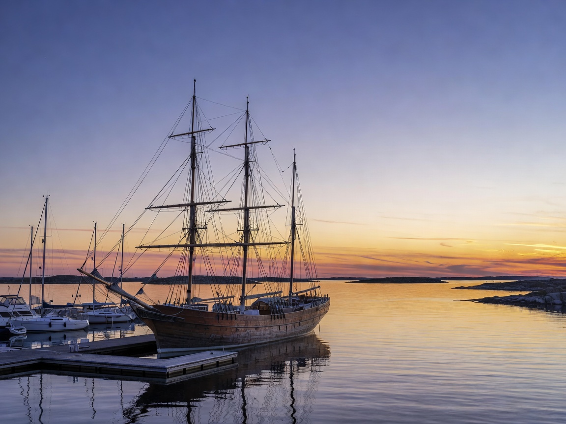 Mariehamn's west harbour in Åland at dusk with a historic four-masted barque and small yachts nearby
